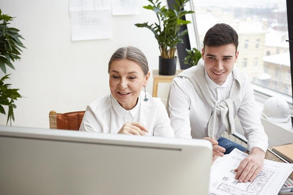 female and male looking at computer monitor