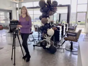 female, Cheryl Barton, standing with Matterport camera on a tripod